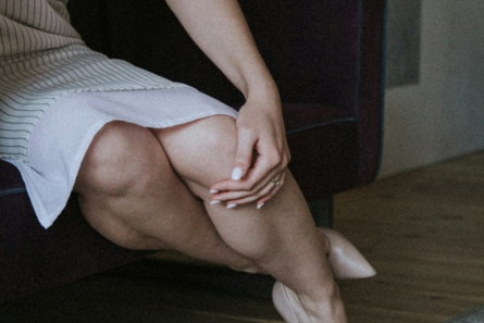 woman in black tank top and white skirt sitting on brown wooden floor