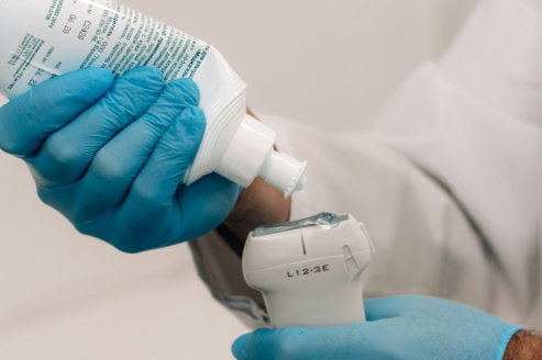 a person in blue gloves is holding a bottle