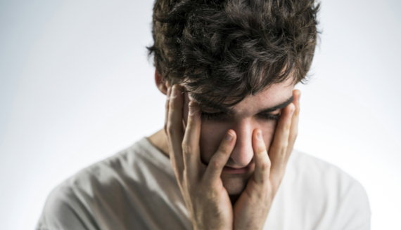 man touching face with both hands