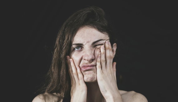 woman covering her face with her hand